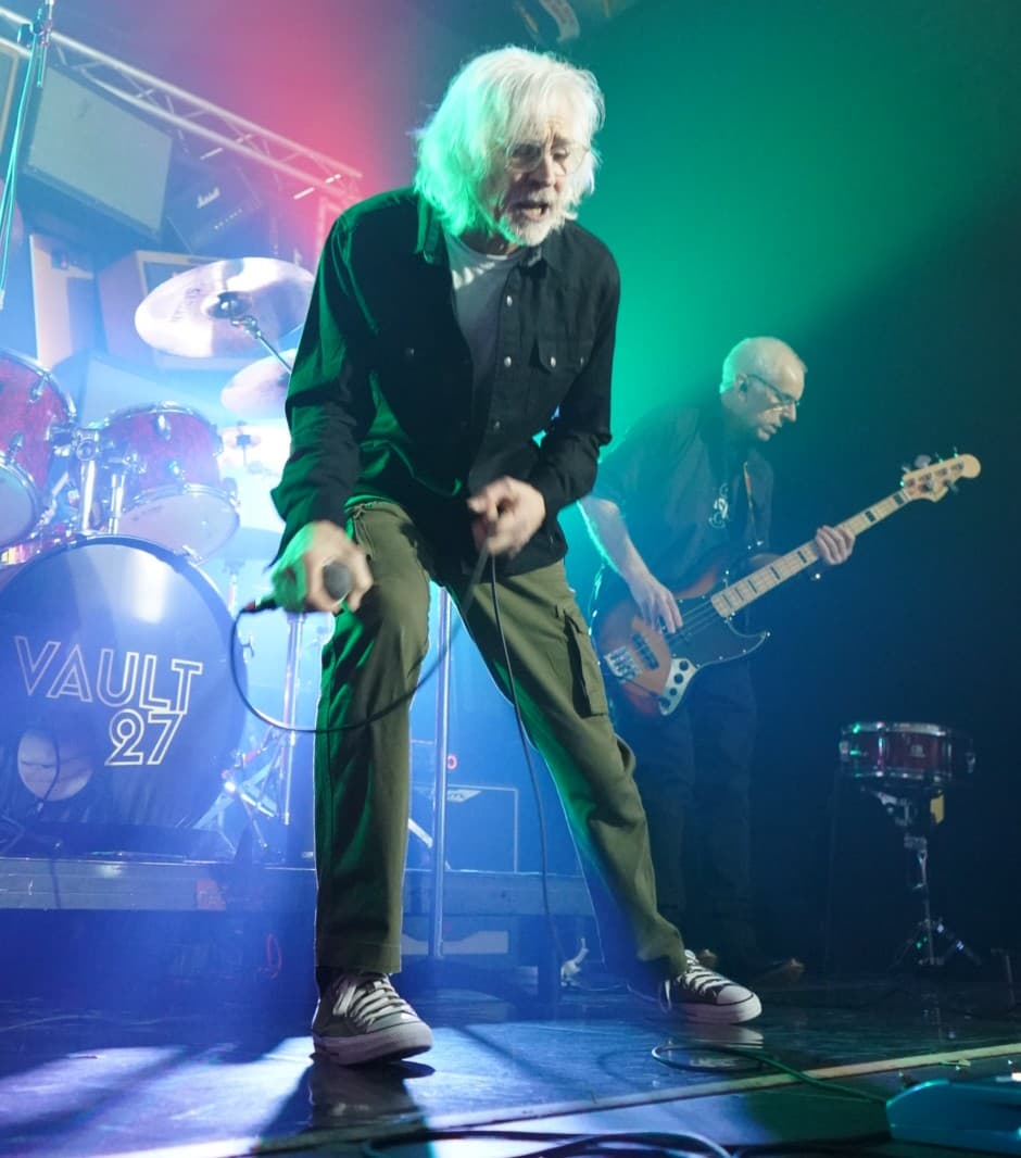 Frontman mid-set under green stage lights